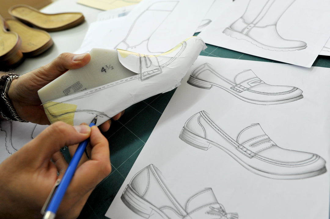 Hands are sketching a shoe design on a last; next to them are technical sketches for the Sioux model development.