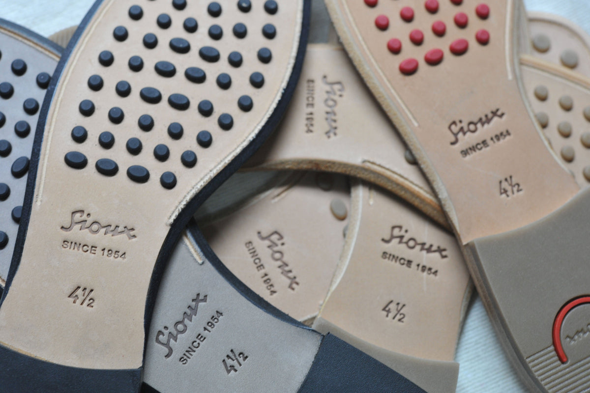 Various Sioux leather shoe soles with colored rubber studs and an embossed Sioux logo.
