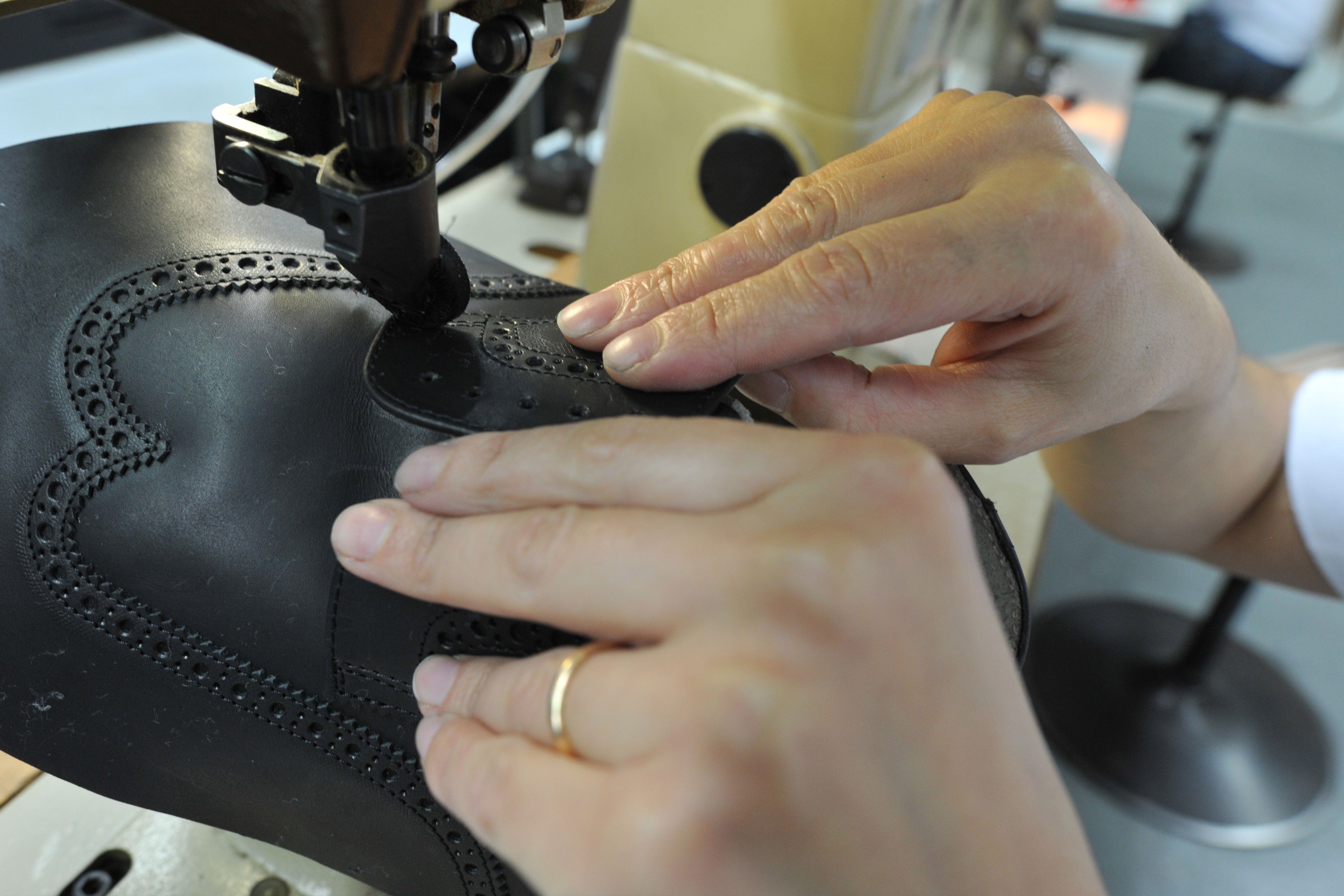 A close-up of the San Crispino construction method at Sioux, in which a black leather upper is precisely sewn on a sewing machine.