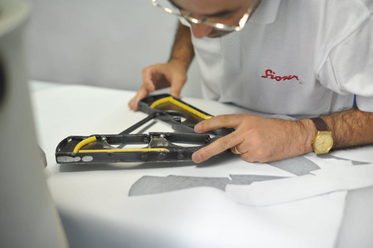 Caption: A Sioux employee inspects a die-cutting blade used for the precise cutting of leather parts in shoe manufacturing.