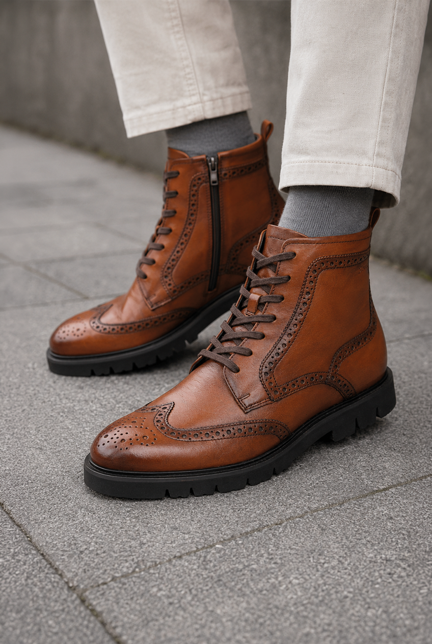 Braune Sioux Herren-Stiefel aus Leder mit Brogue-Verzierungen, Schnürung und schwarzer Profilsohle.